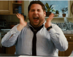 Man laughing with both hands raised in excitement